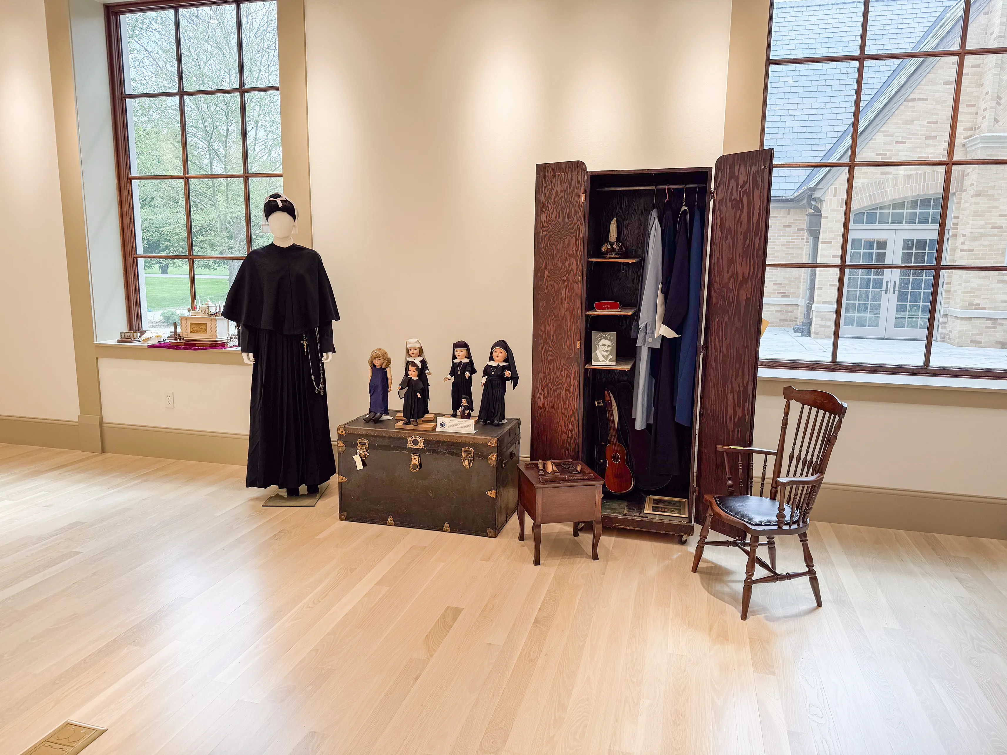 Museum display of a habit, dolls, and preserved artifacts at HARC