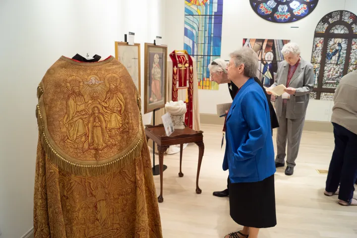Visitors viewing vestments and stained glass on display at HARC