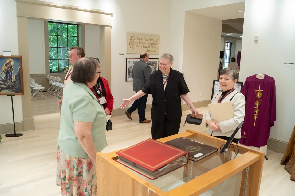 Visitors gathered around an archival display case at a HARC reception