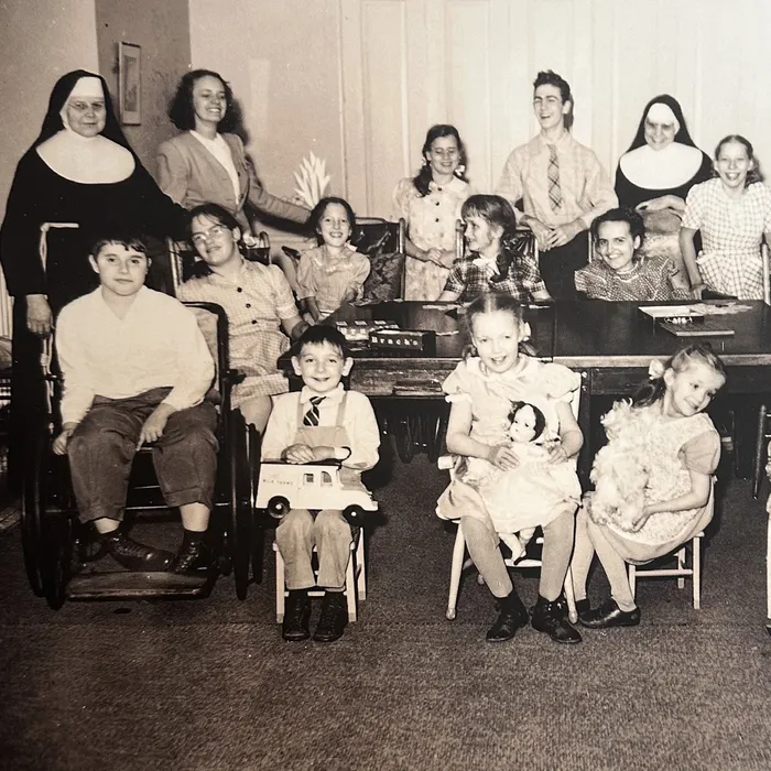Archival photograph of a Sister seated with a group of children