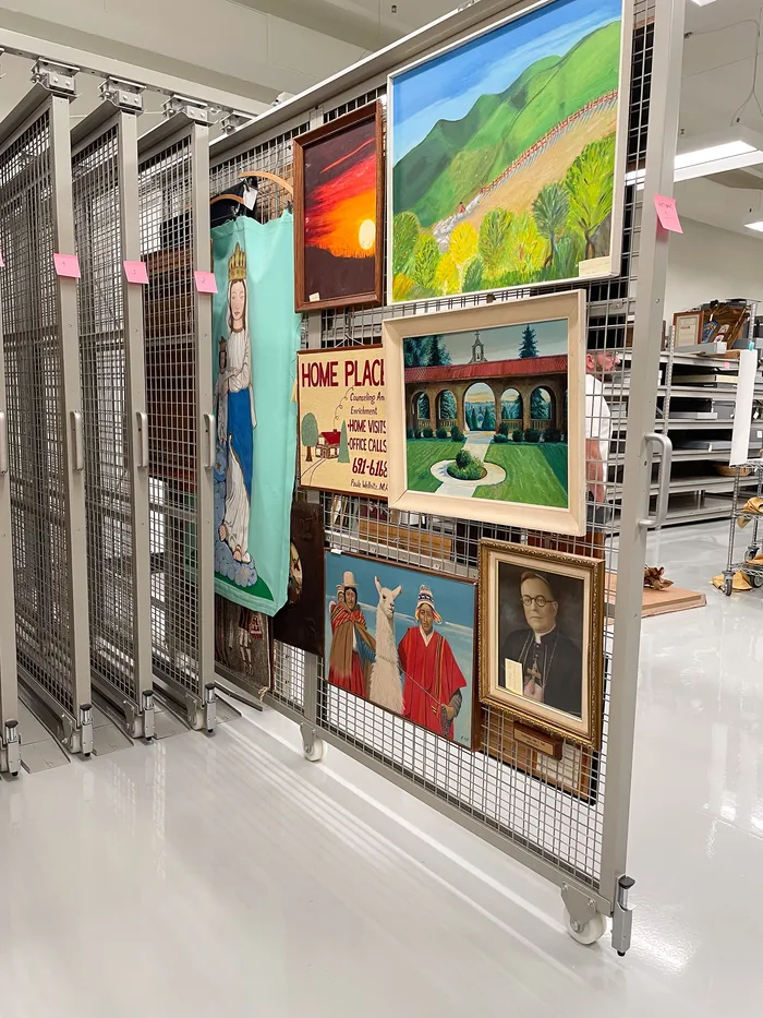 Rolling storage cart holding framed paintings and textiles in the collections room
